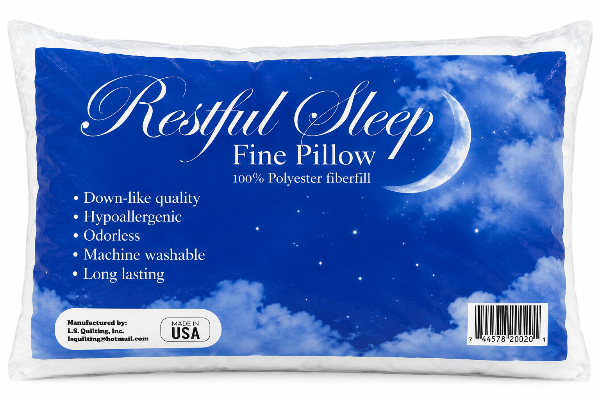 A Restful Sleep Fine Pillow in a white plastic bag with a large blue sky and moon graphic label. The label features white text describing it as 100% polyester fiberfill and lists product benefits.